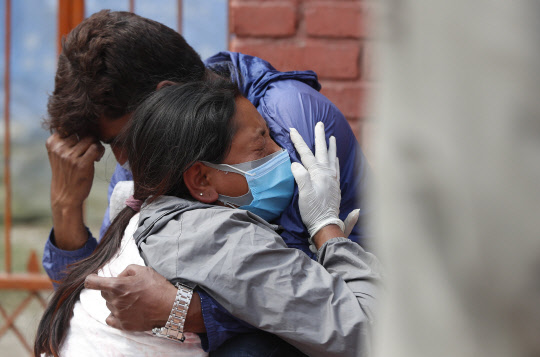 네팔 수도 카트만두의 한 화장장에서 지난달 30일(현지시간) 코로나19 사망자의 유가족들이 오열하고 있다. 코로나19가 대확산 중인 인도의 인접국 네팔에서도 최근 들어 하루 신규 확진자가 수 천명씩 쏟아지고 있다.  <카트만두 AP=연합뉴스>